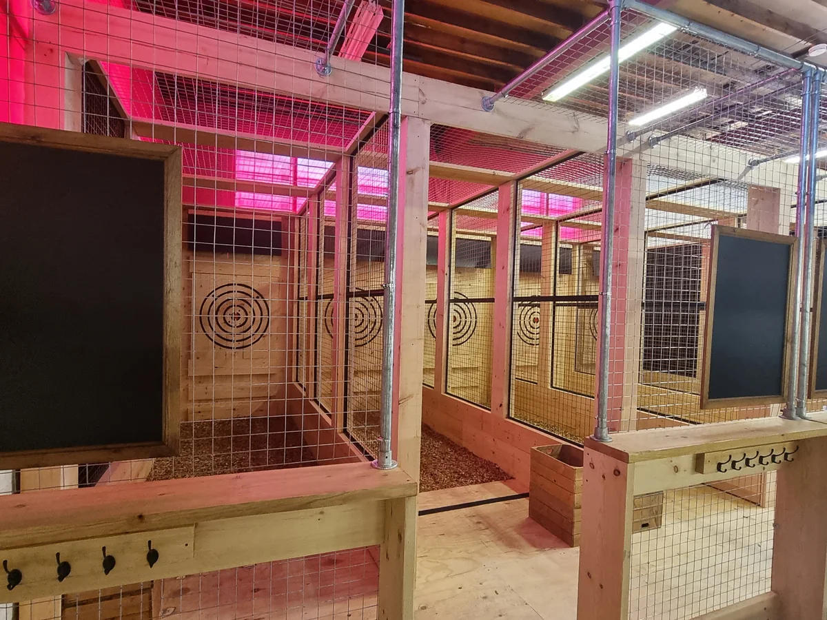 Traditional timber throwing lanes arranged across a commercial venue under red lighting