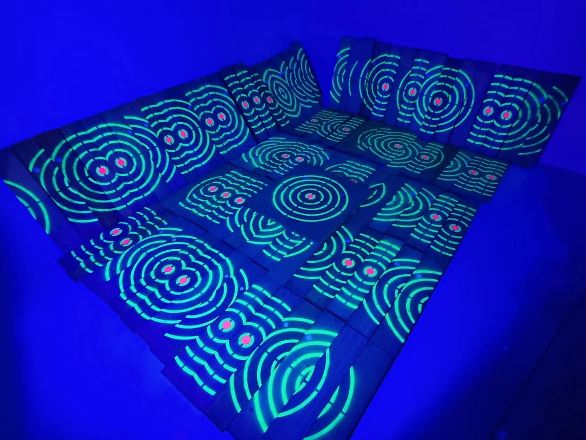 UV-reactive bespoke timber target boards arranged under blue lighting